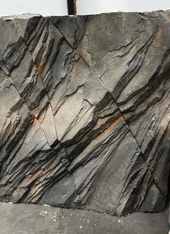 Layered slate rock formation with natural striations